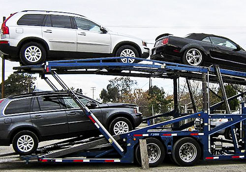 grupo de autos nuevos siendo transportados sin rodar por madrina nodriza color azul